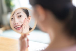 自分の顔を見る女性